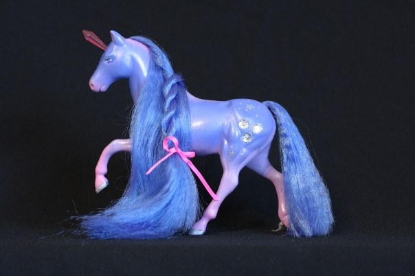 Prisma; Body Color: Blue, Purple, and Pink<br/>Hair Color: Dark Blue<br/>Horn Color: Pink <br/>Jewel Color: Silver<br/>Brush: Dark Blue <br/> Accessories: 2 Hot Pink Ribbons<br/>Notes: Front and back of mane is in a twisted braid, tail is also in a twisted braid secured with silver elastic. Body accented with silver stars and dots. Prisma's pose is only used by her.